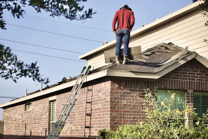 Professional roofer working on a residential roof in West City